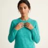 polera-alpaca-celeste-mujer-detalle-cara-manos-yordall Polera lana alpaca celeste mujer con panel trenzado en el pecho, cuello redondo, manga larga — Yordall Chile
